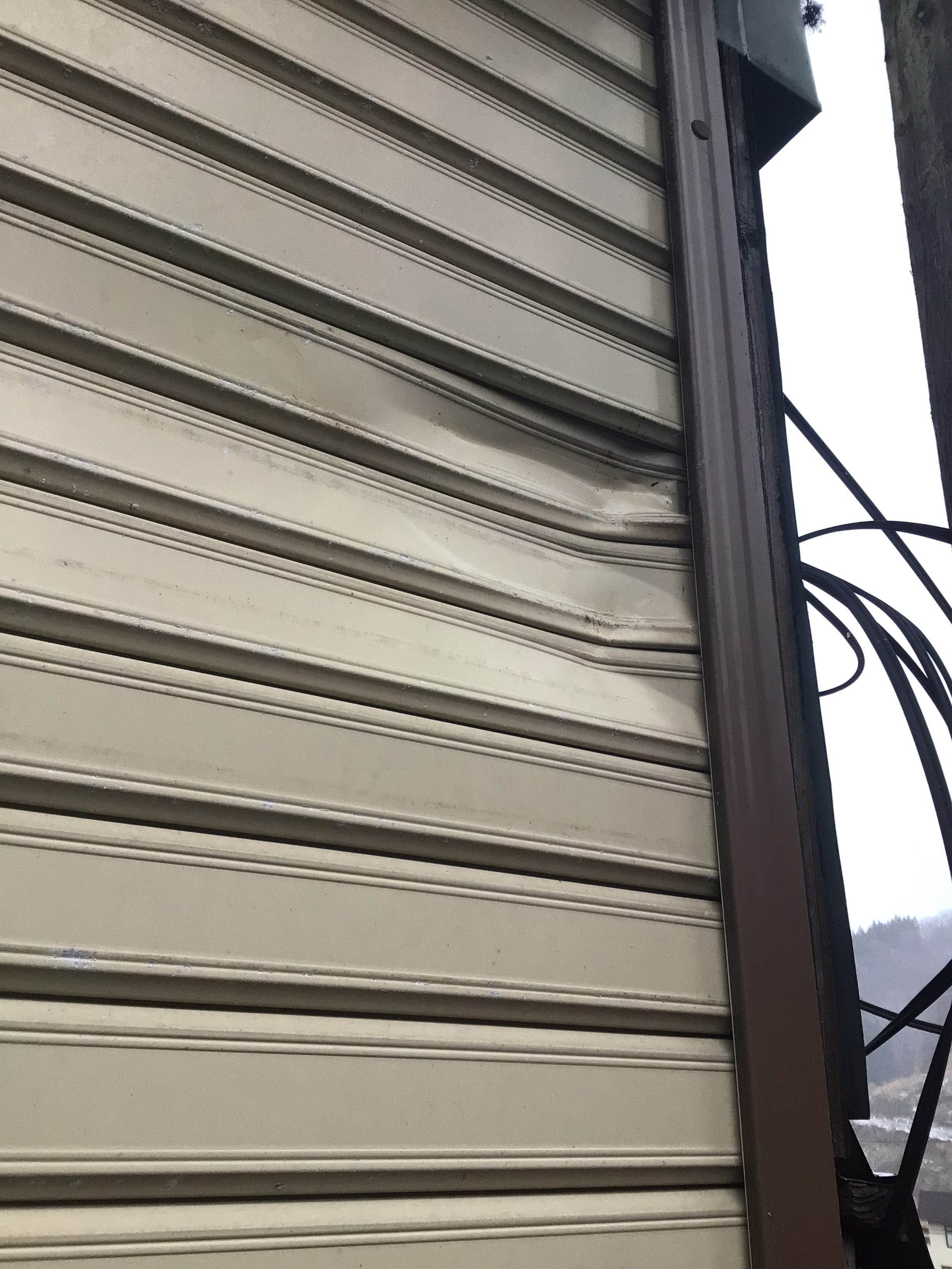 シャッタースラットがへこみや波打ちで変形している様子の写真